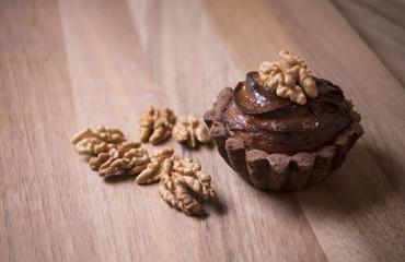 Fototapeta na wymiar Delicious muffins with nuts placed on a wooden table
