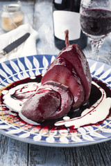 Traditional poarched pear in wine sauce as close-up on a plate