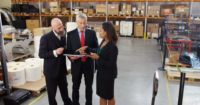 4k, Warehouse managers inspecting inventory in a large distribution warehouse.