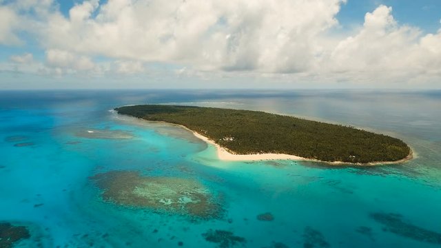 Aerial view of beautiful tropical island Daco with white sand beach. View of a nice tropical beach from the air. Beautiful sky, sea, resort. Seascape: Ocean and beautiful beach paradise. Philippines