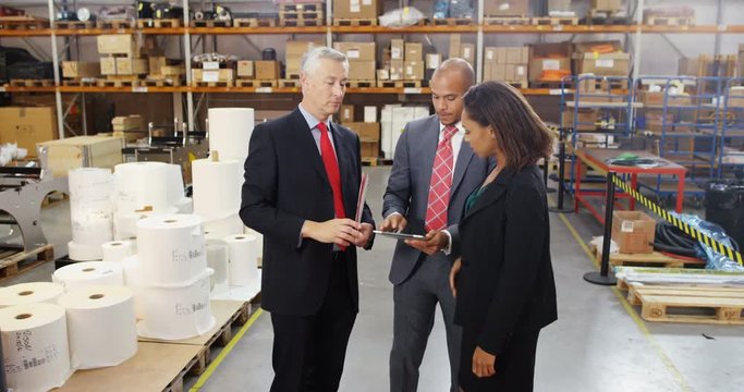 4k, Three warehouse workers discussing logistics of their business in a warehouse.