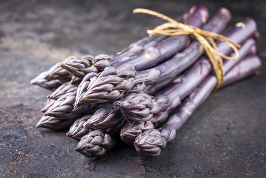 Row purple Asparagus as close-up on an old metal board with copy space