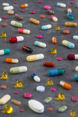 Pharmacy theme. Multicolored Isolated Pills and Capsules on grey slate background