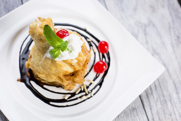 ried icecream with whipped cream and cherry on top and chocolate dressing