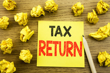 Naklejka premium Word, writing Tax Return. Business concept for Accounting Money Return written on sticky note paper on the wooden background. Folded yellow papers on the background
