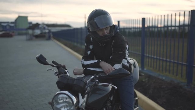 young attractive motorcyclist with black helmet on street. Man motorcycle biker 