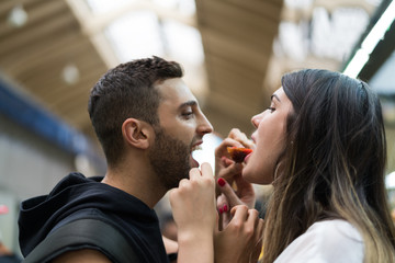 Boyfriend joking girlfriend with strawberry