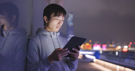 Man use of tablet computer at night