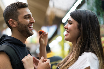 Boyfriend joking girlfriend with strawberry