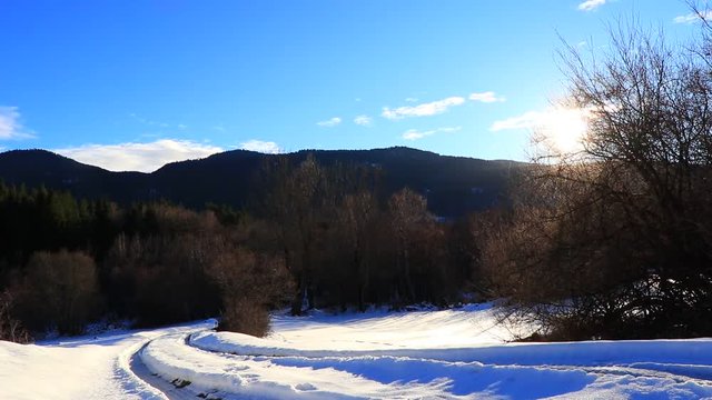 snowy path in winter in Pyrenees with shining sun filmed in traveling, Aude in south of France
