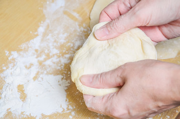 Woman doing manually the flat cake of leavened wheat dough