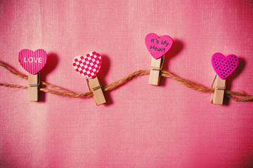 Decoration heart shape clothes pegs on pink background, Valentine concept