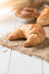 Homemade croissant on white wood background