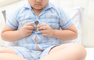 Obese fat boy overweight. Tight shirt of pajamas