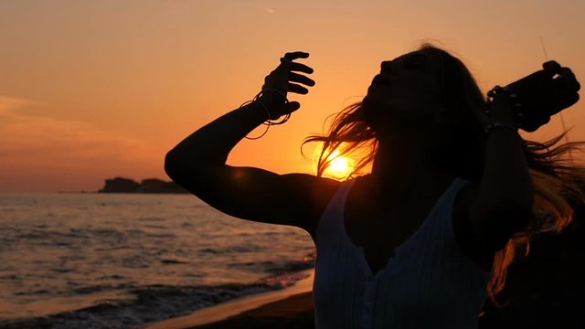 Silhouette Of Woman  At Sunset Walking alone On Beach - Slow Motion
