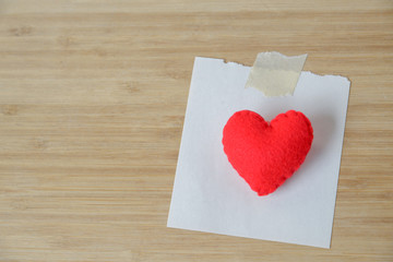 Red heart and note paper and wood background, Valentine concept.