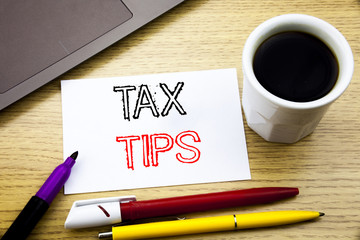 Handwritten text caption showing Tax Tips. Business concept writing for Taxpayer Assistance Refund Reimbursement written on notebook book on the wooden background in the Office with laptop coffee
