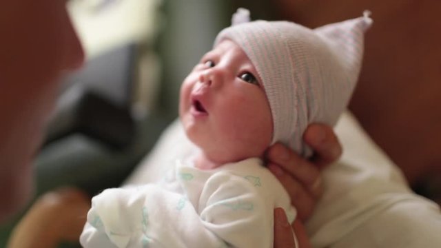 Father Kissing Newborn Baby in Hospital