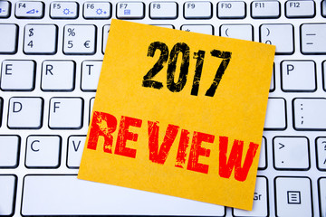 2017 Review. Business concept for Annual Summary Report written on sticky note paper on the white keyboard background.