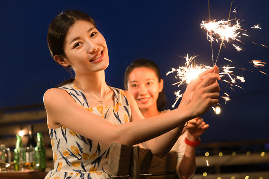 Two young women set off fireworks
