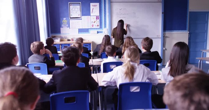 4k, Attractive female teacher teaching a classroom in front of a whiteboard. Slow motion.