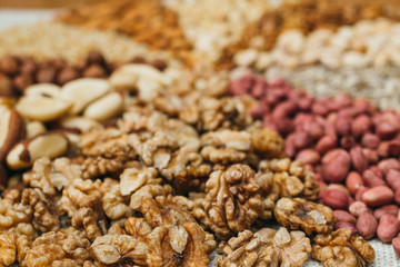 Nuts mix in a canvas bag in table. Ten kinds of nuts: pecan, brazil, cedar, sunflower, hazelnut, almond, peanut walnut pistachio cashew