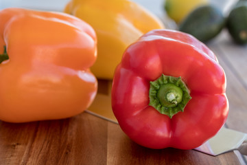 Fresh bell peppers on wooden cutting board