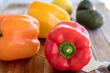 Fresh bell peppers on wooden cutting board
