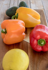 Fresh bell peppers on wooden cutting board