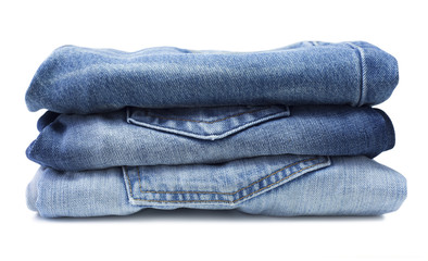 Stack of blue jeans isolated on white