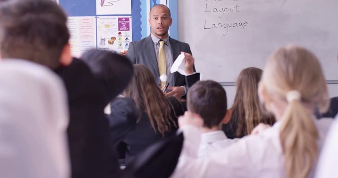 4K Teacher in class has no control over his students, unruly children throw rolled up papers at him. Slow motion