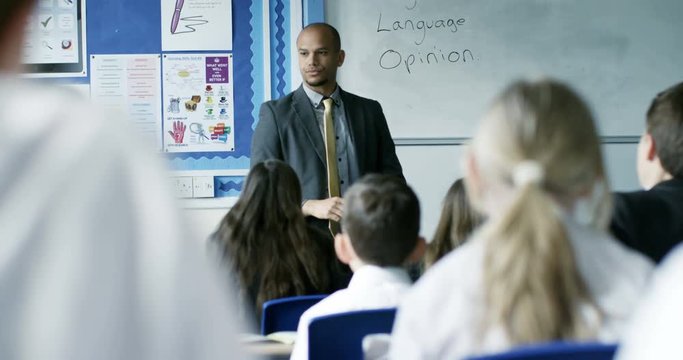 4K Teacher in class has no control over his students, unruly children throw rolled up papers at him. Slow motion