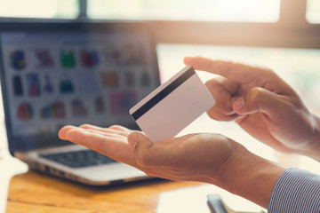 Businessman holding credit card and using laptop to shopping online