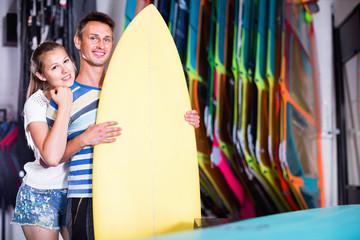 Couple is satisfied of colorful boards in store on the beach.