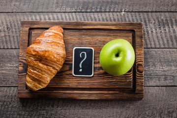 Healthy and unhealthy food. Green Apple vs Croissant. Diet Concept