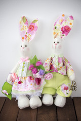dolls rabbits sitting at a white wall