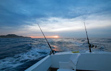 Fototapeten Morning sunrise view of fishing rod on charter fishing boat on the Pacific side of Cabo San Lucas in Baja California Mexico BCS © htrnr