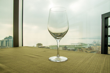 Empty wine glass on the table in front of a window