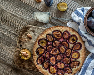Homemade plum pie on the wooden background