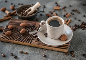 Black coffee with candies on a concrete background