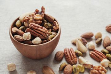 Mixed nuts in wooden bowl, healthy fat and protein food, vegan, ketogenic diet, plant based diet, natural sources of tryptophan for getting good sleep and relaxation