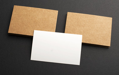 Brown and white business cards on black background. Mockup.