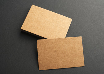 Brown business cards on black background. Mockup.