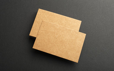 Brown business cards on black background. Mockup.