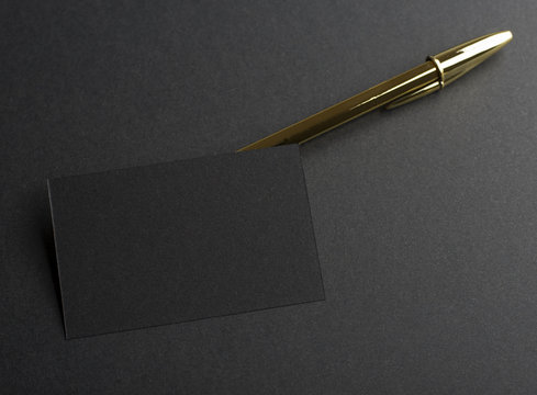 Black Business Card Next To Golden Pen On Black Background. Mockup.