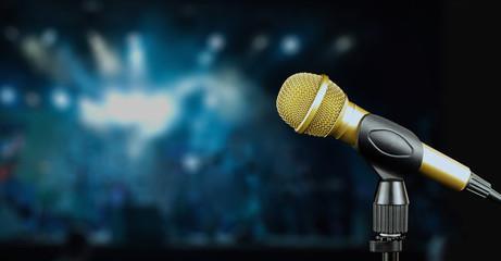 Golden microphone on stage, blurred background