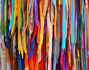 Colored bright shoelaces hang in the store