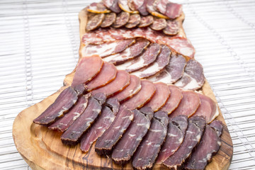 different kinds of cut ham on a wooden board