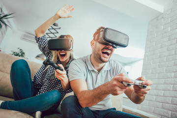 Happy friends playing video games with virtual reality glasses - Young people having fun with new technology console online - Powered by Adobe