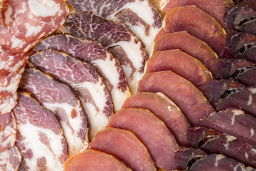 different kinds of cut ham on a wooden board